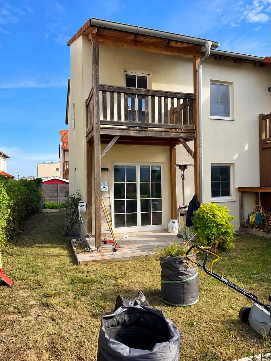 Garden after: lawn mown in front of the terrace and balcony, garden bags at the front, the lawnmower on the right